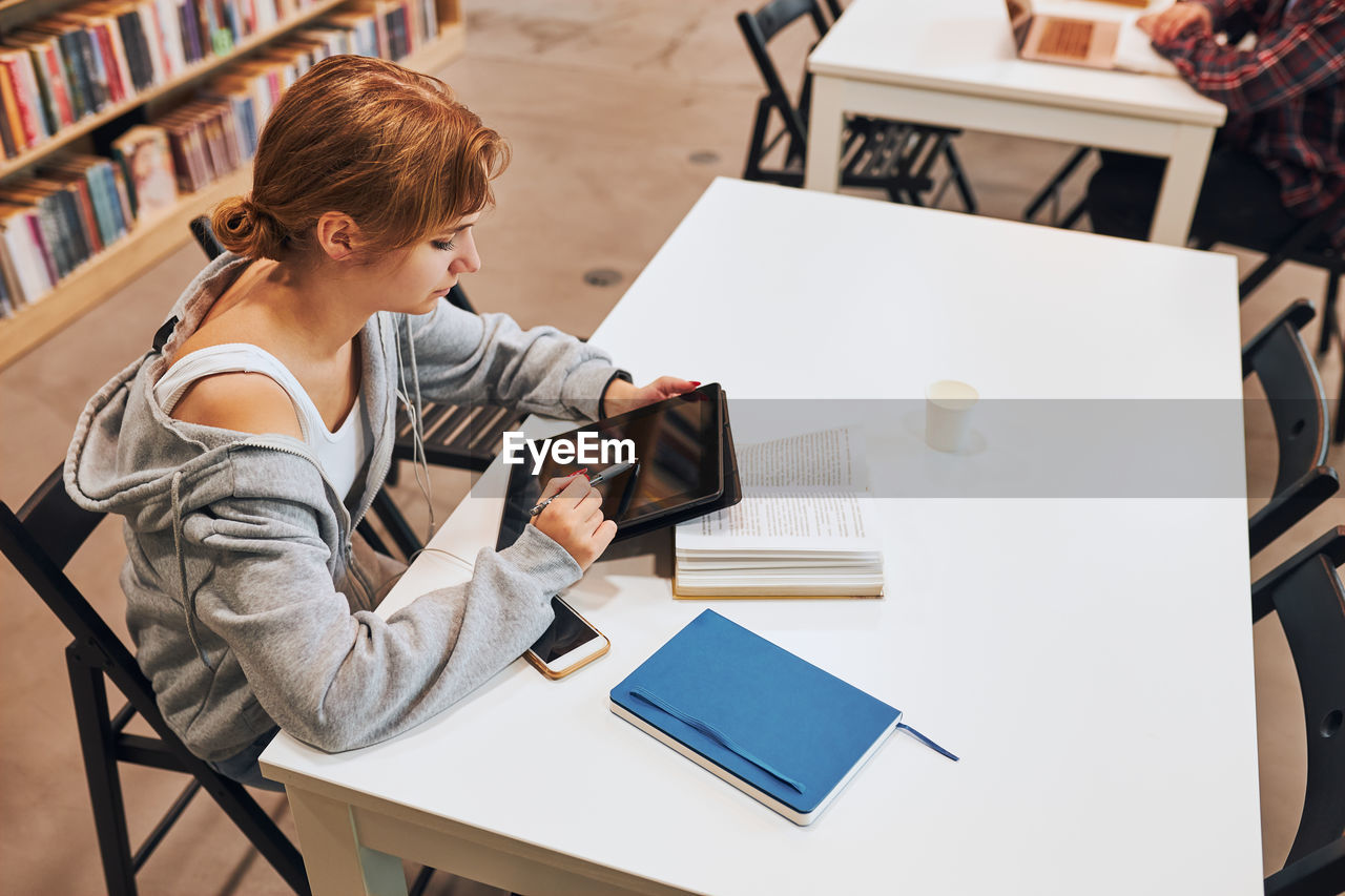 Student learning in university library. young making notes using computer tablet. back to school