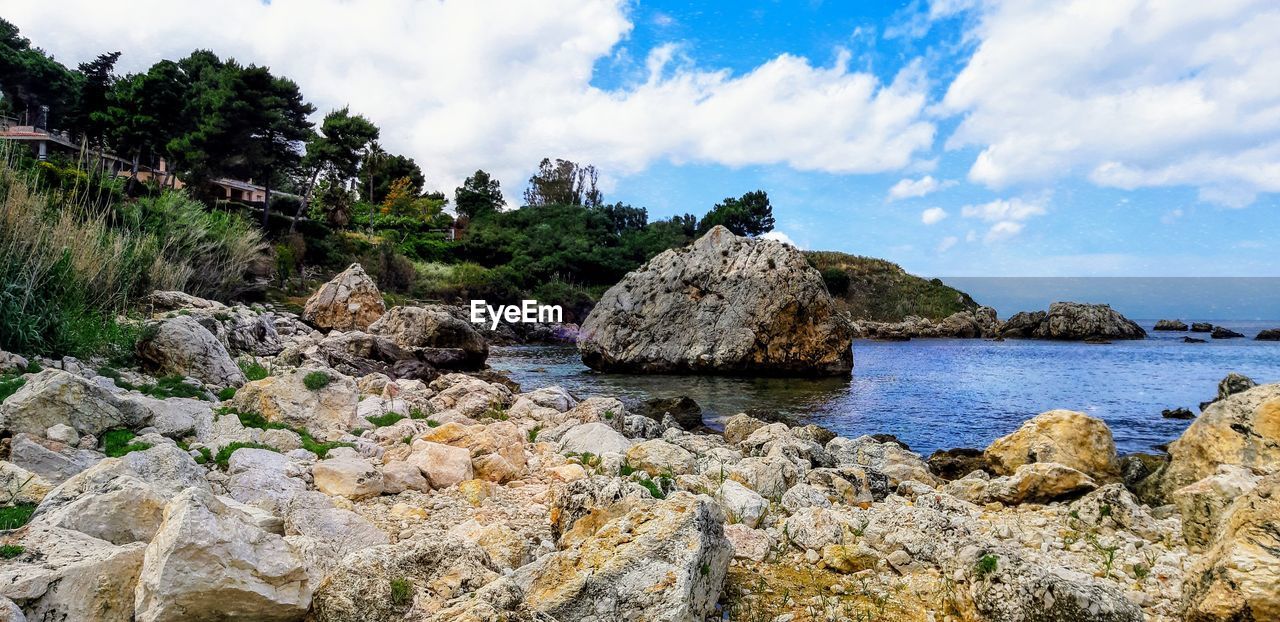 Panoramic view of rocks on beach against sky