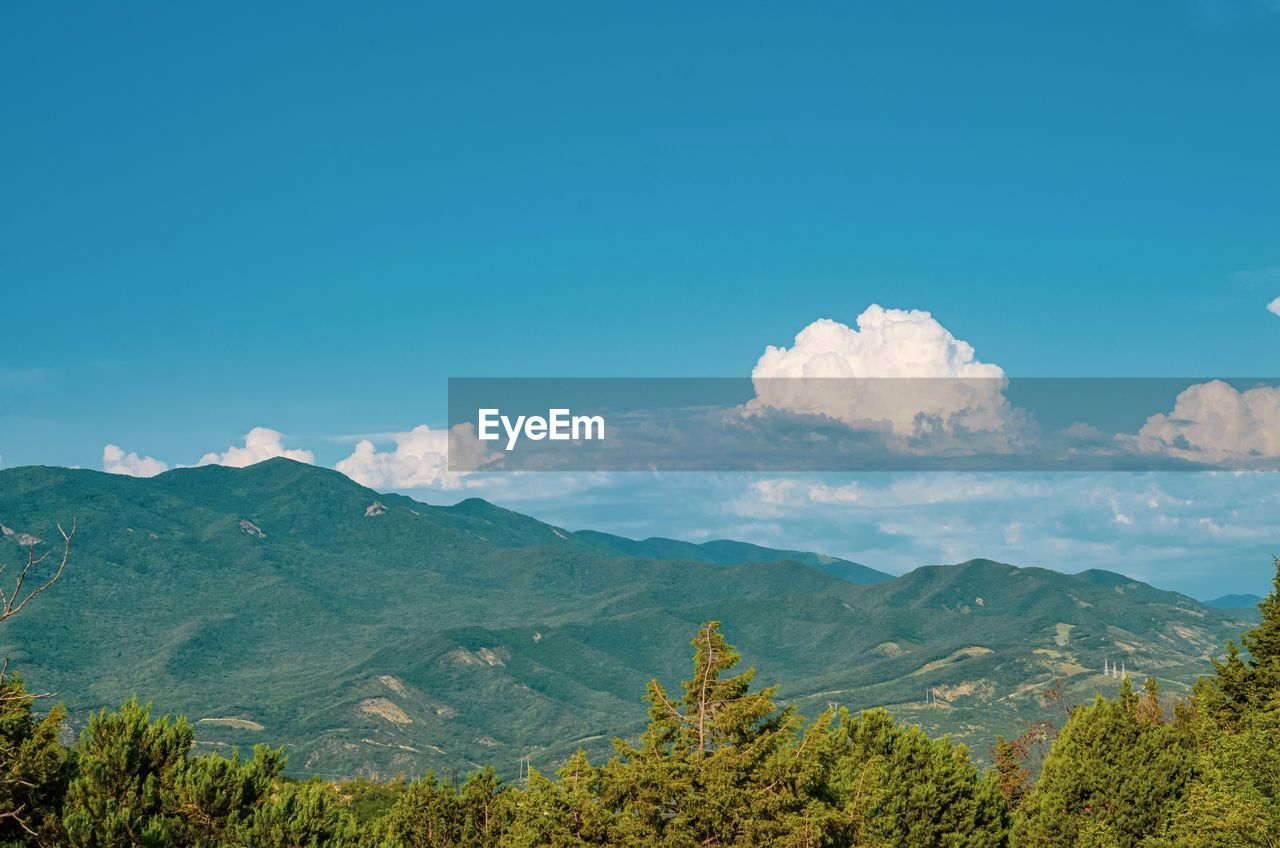 Scenic view of mountains against blue sky