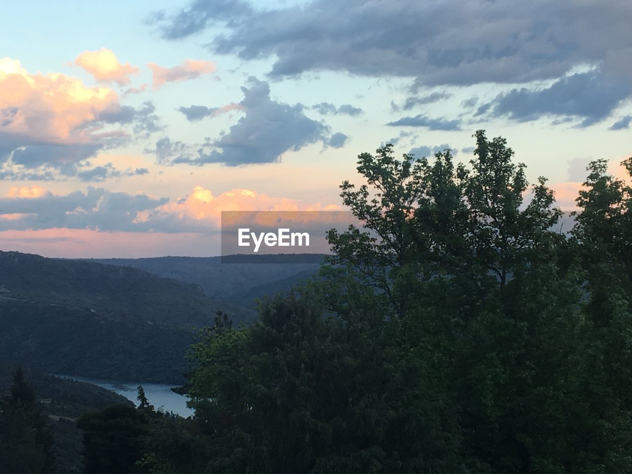 SCENIC VIEW OF TREE MOUNTAINS AGAINST SKY DURING SUNSET