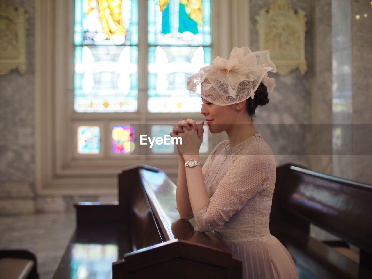 Side view of bride sitting in pew