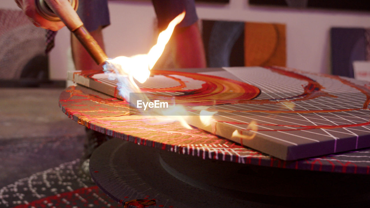 CLOSE-UP OF LIT CANDLES ON FIRE