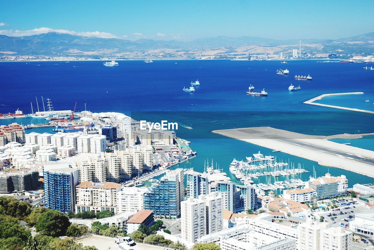 High angle view of cityscape by sea against sky