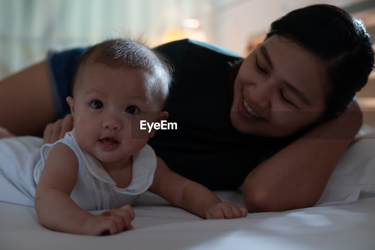 Mother playing with cute girl at home