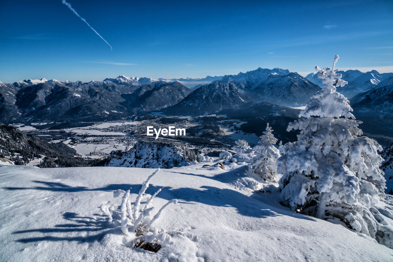 Scenic view of snowcapped mountains against blue sky