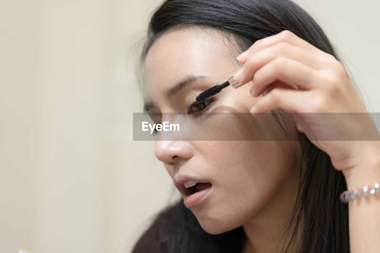 Close-up of woman applying mascara