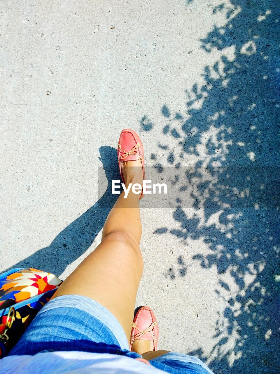 Low section of woman walking on road