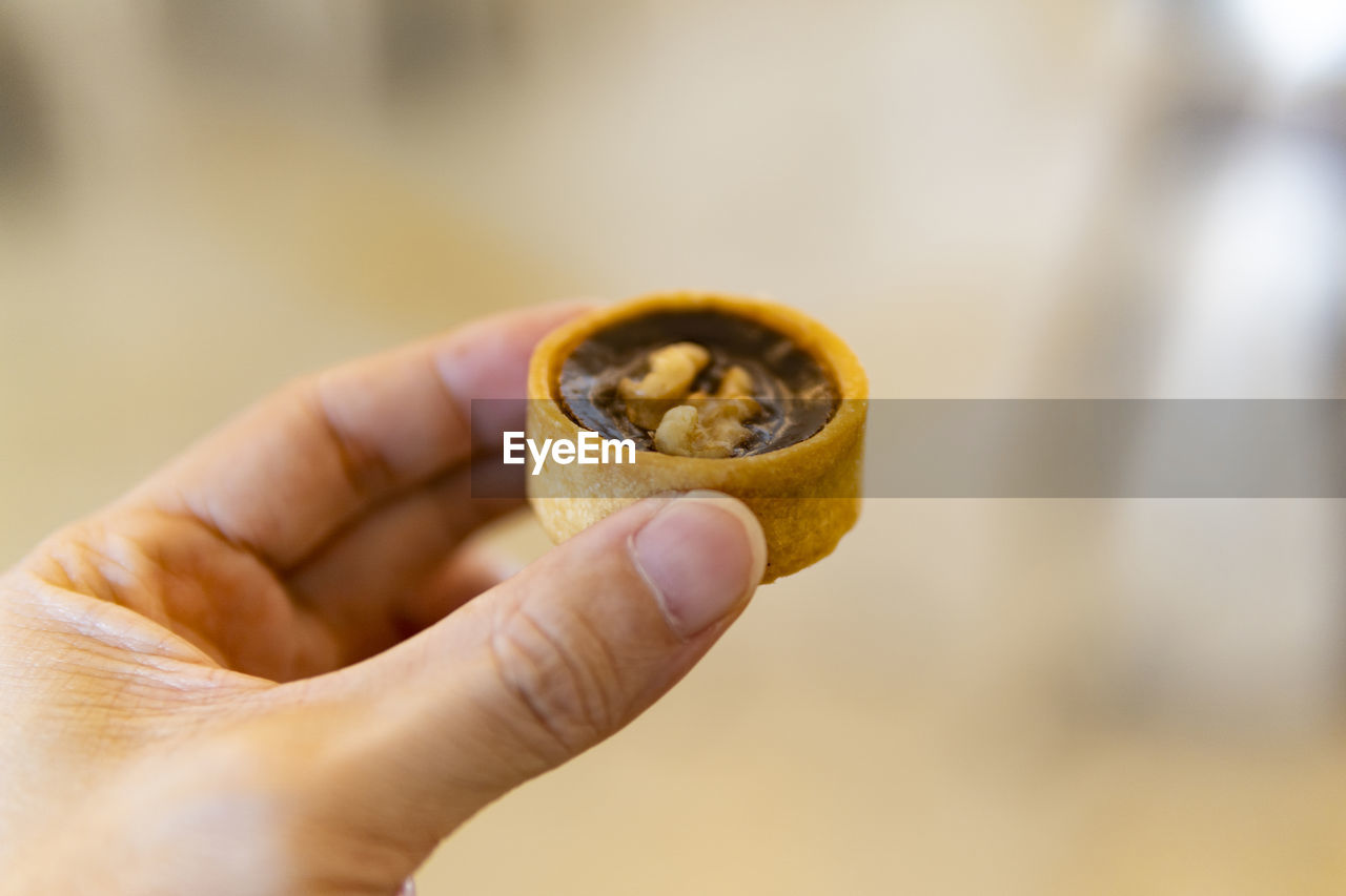Close-up of person holding mini tart
