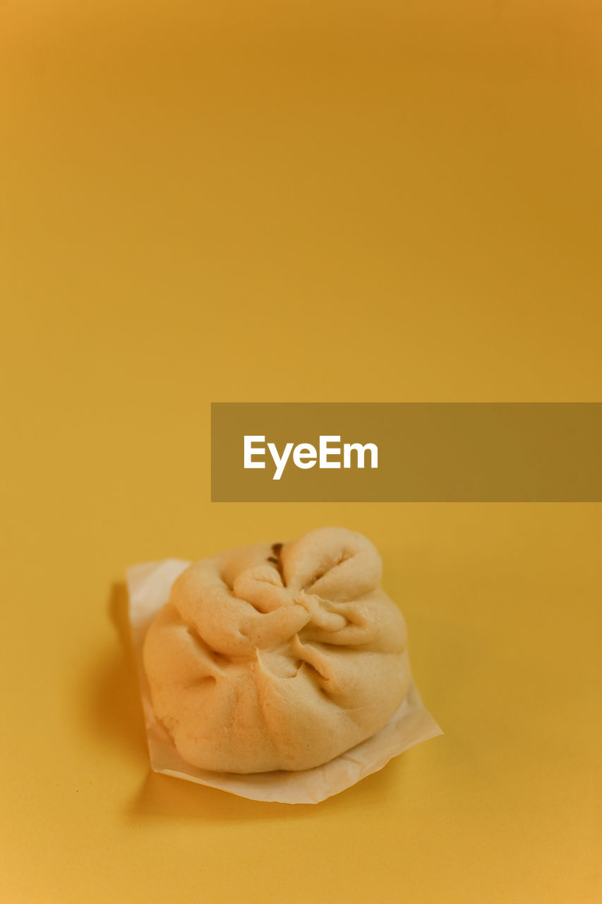 High angle view of meatbun or bakpao on yellow background