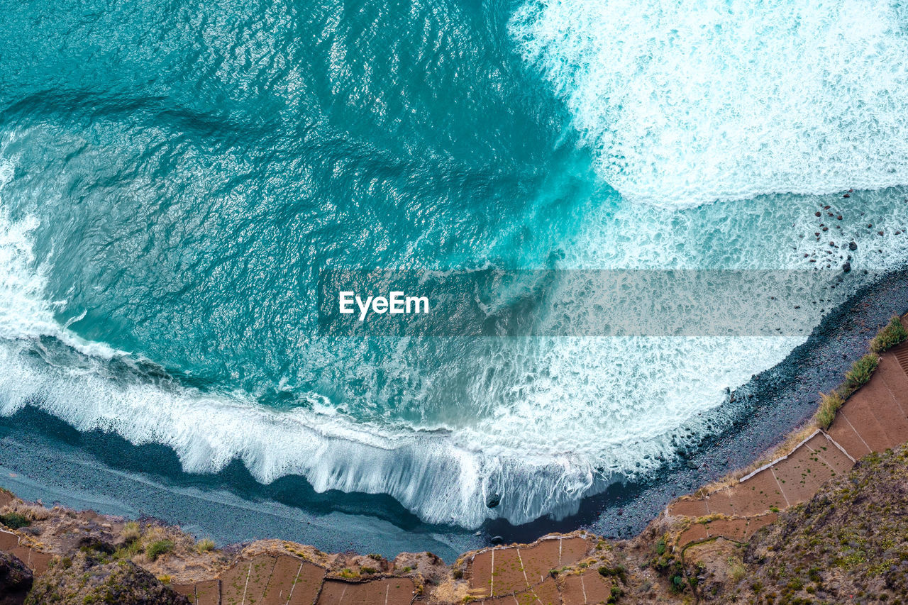 HIGH ANGLE VIEW OF WAVE SPLASHING ON ROCK