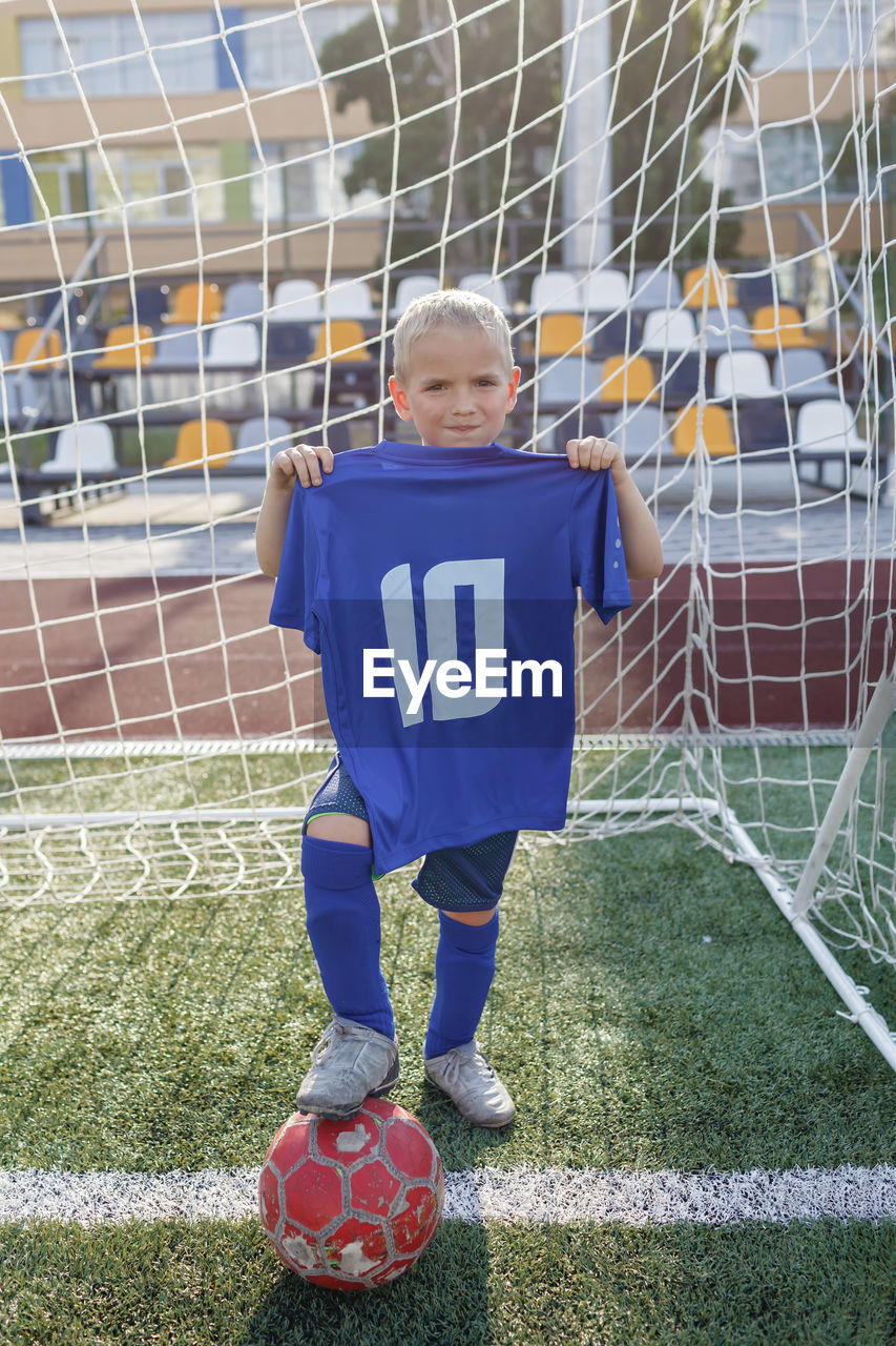 Full length of a boy ball on soccer field