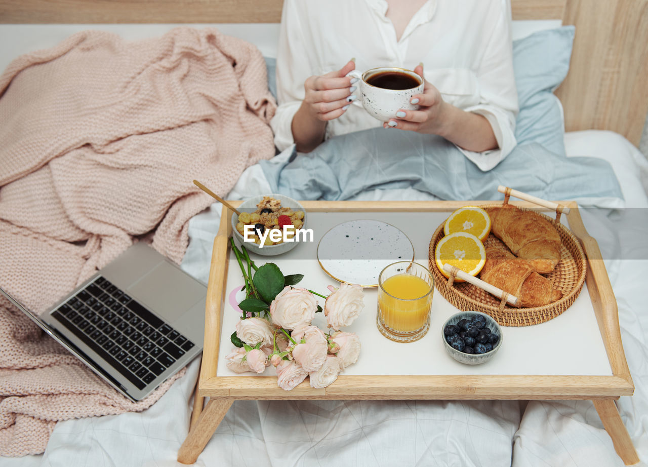 Romantic breakfast with coffee, waffles, orange juice and rose flowers.