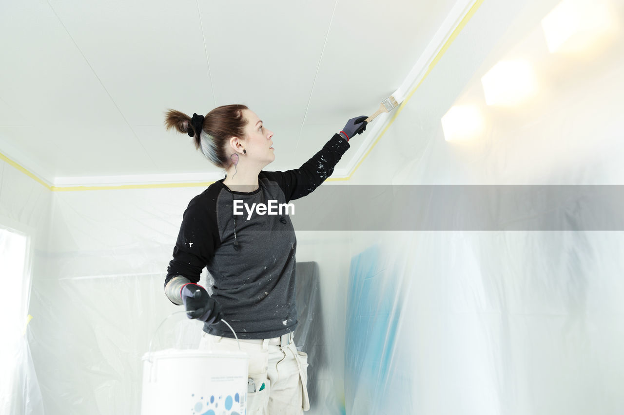 Woman painting ceiling