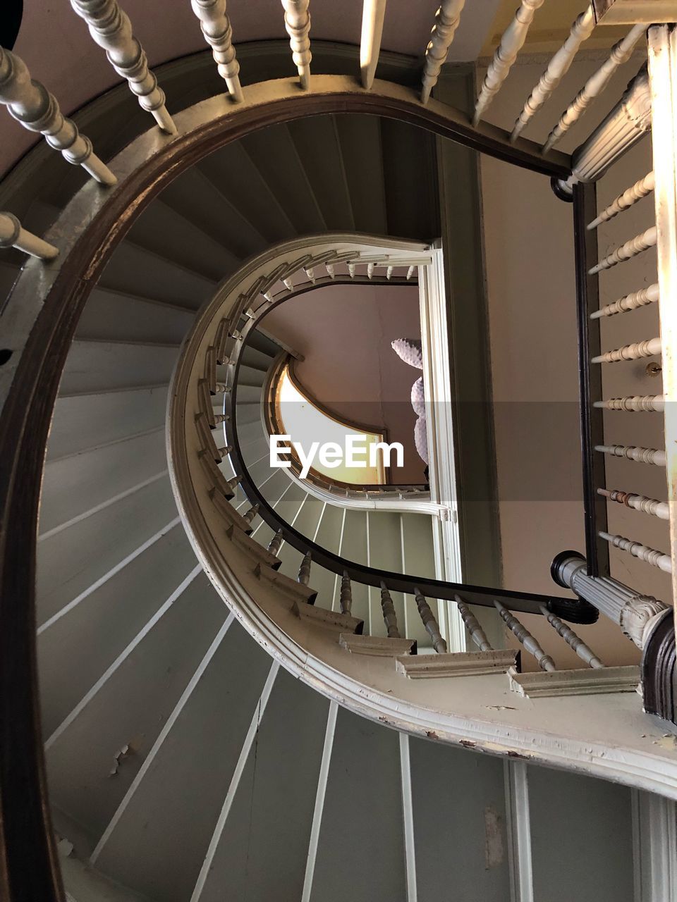 DIRECTLY BELOW SHOT OF SPIRAL STAIRCASE OF BUILDING