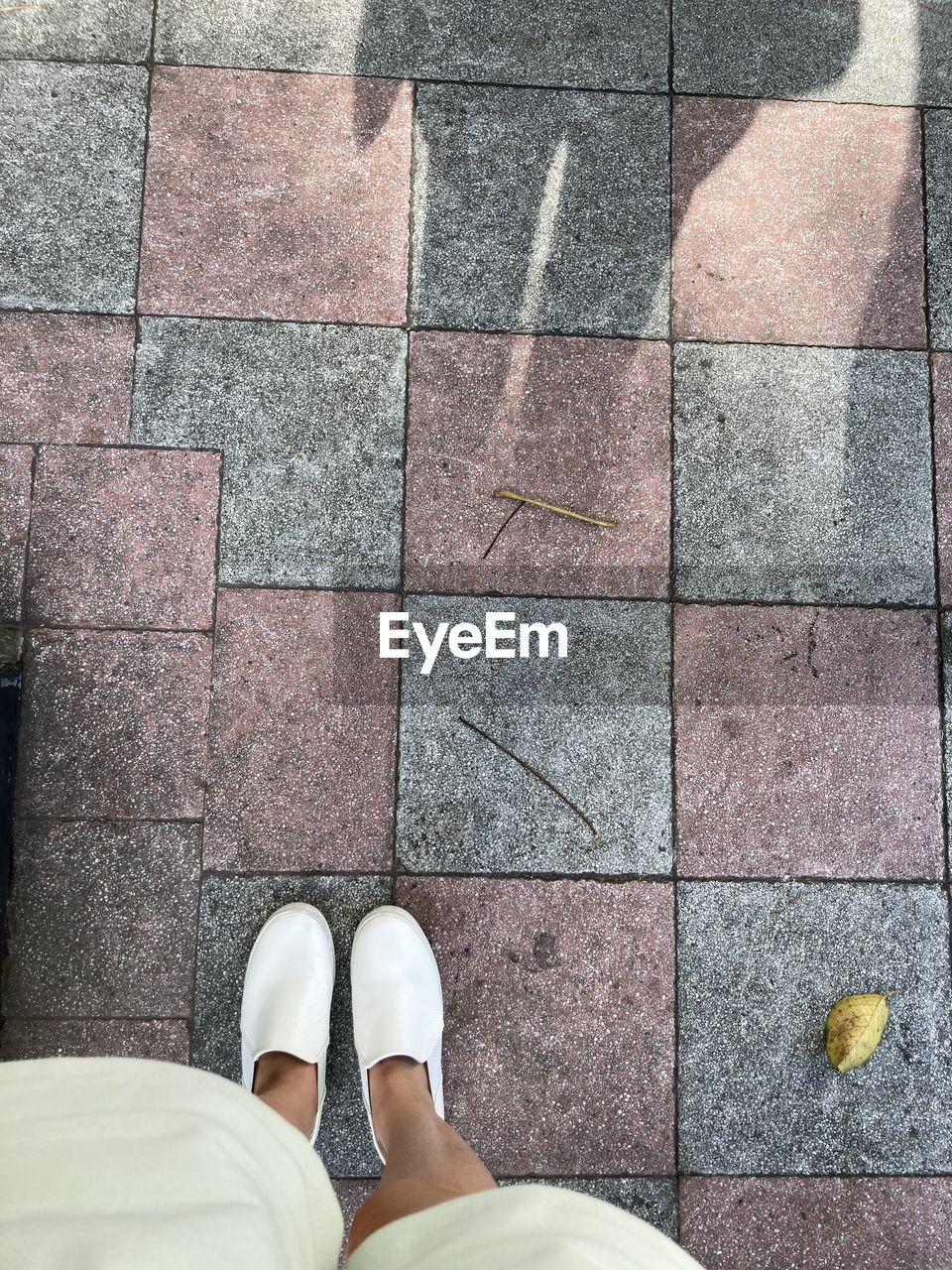 LOW SECTION OF WOMAN STANDING ON FOOTPATH