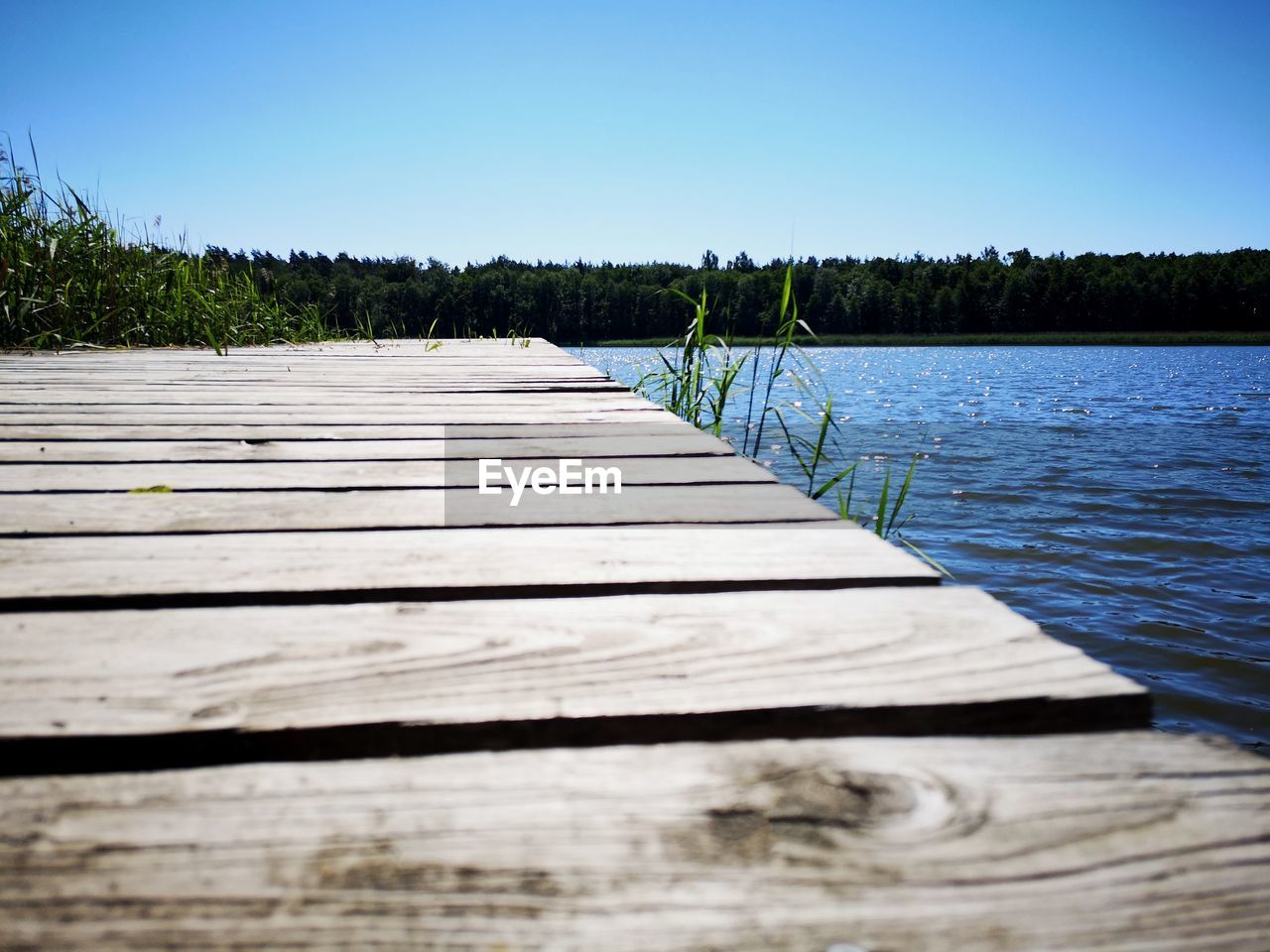 WOODEN PIER ON LAKE AGAINST SKY