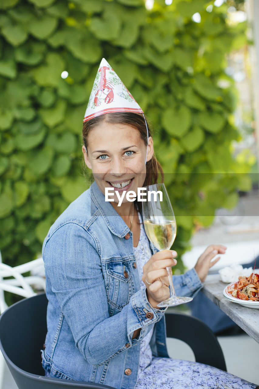 Young woman with champagne flute at crayfish party