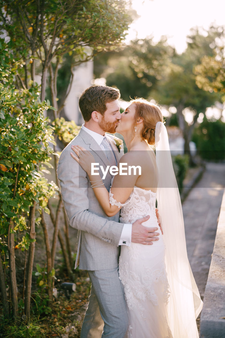 side view of bride and bridegroom holding bouquet