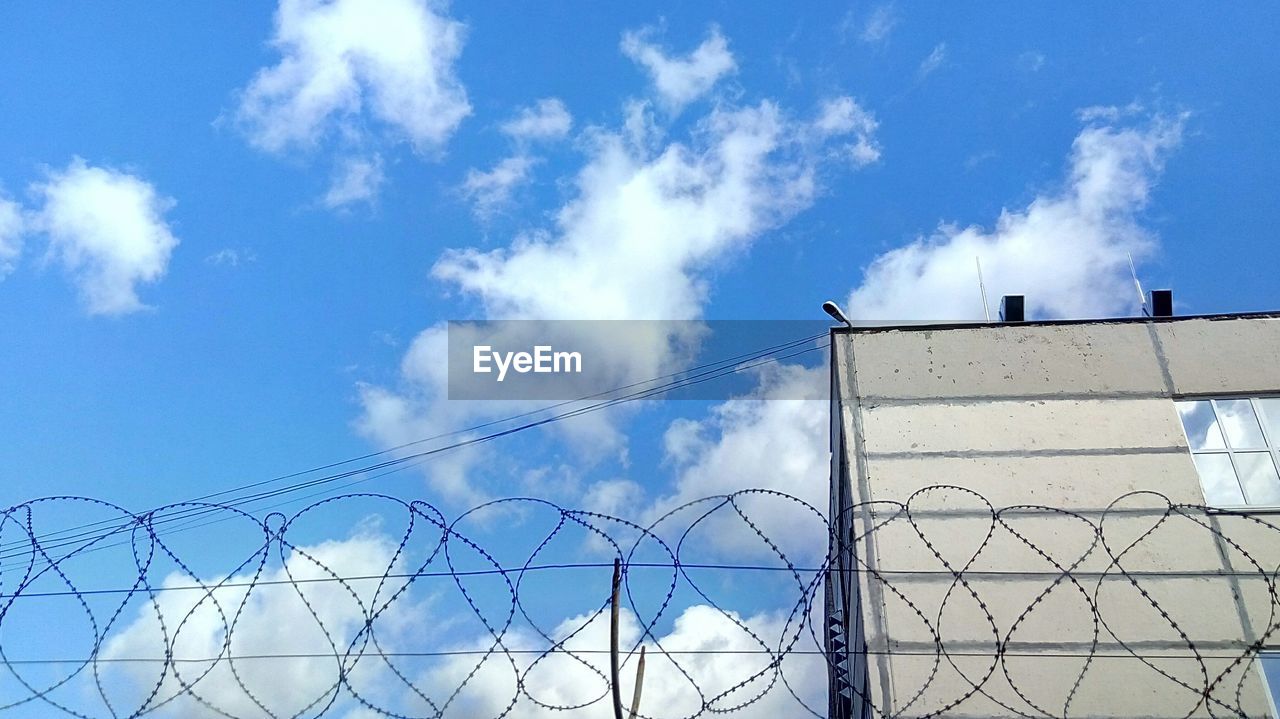 LOW ANGLE VIEW OF BARBED WIRE AGAINST SKY