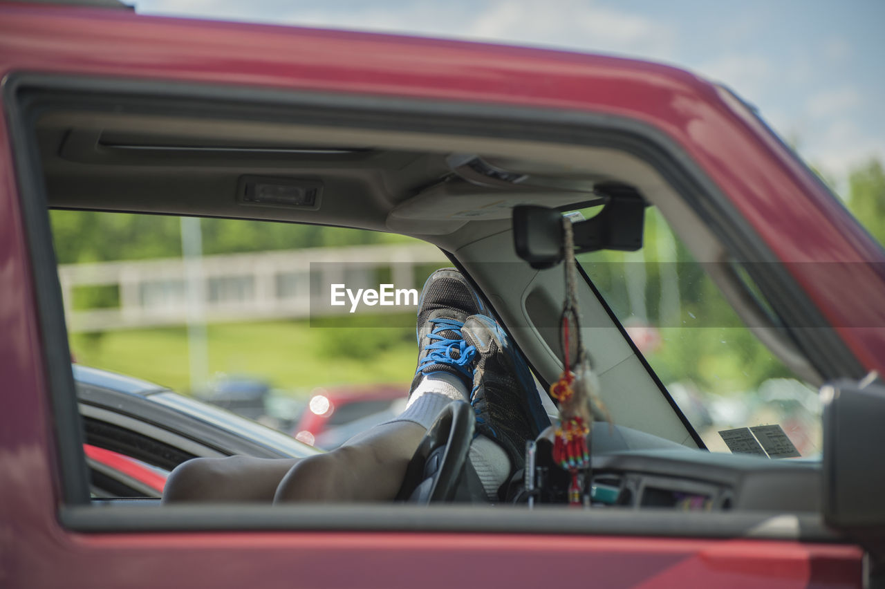 Close-up of man on side-view mirror of car