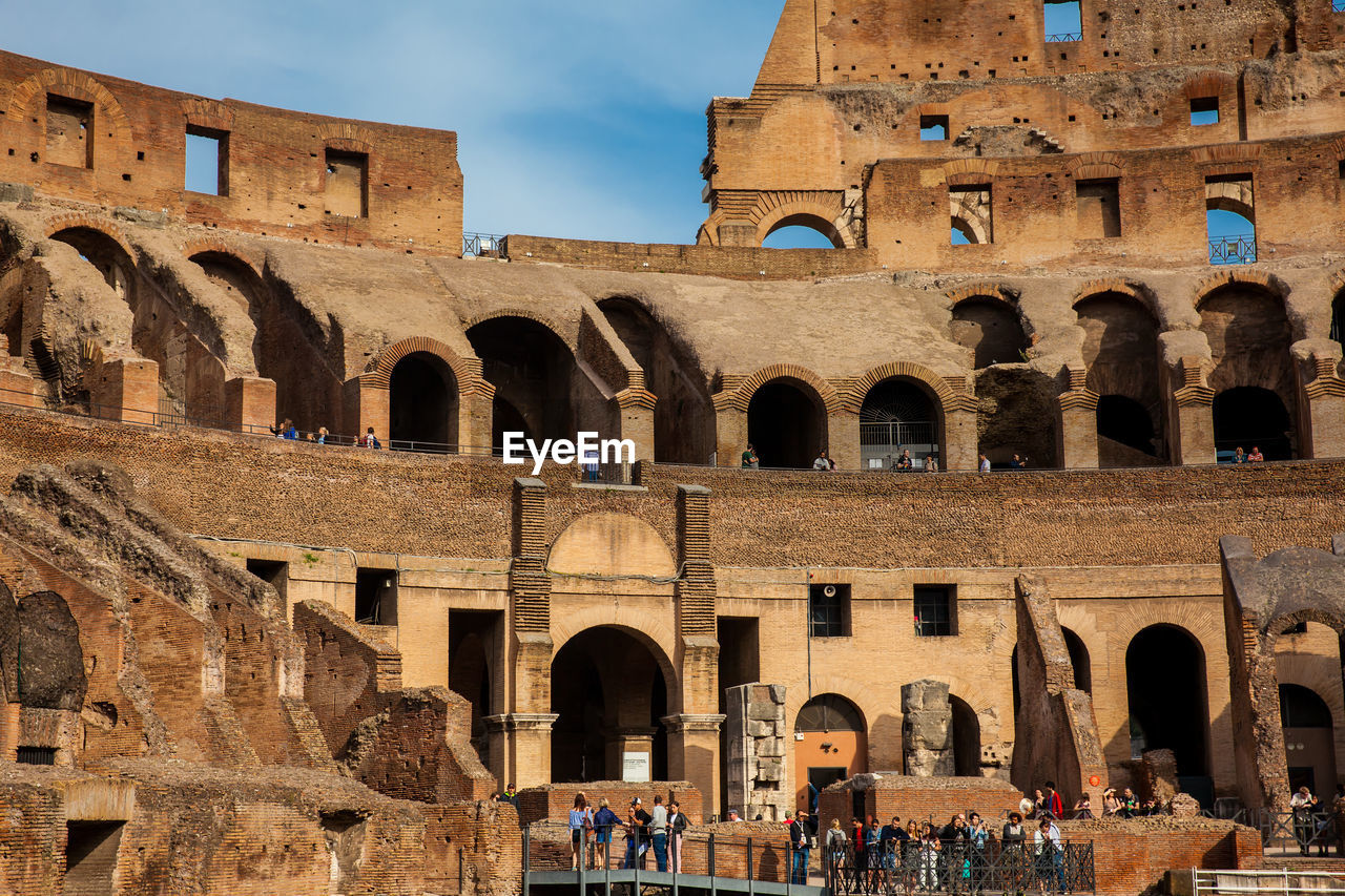 Tourists visiting the interior of the famous colosseum in rome