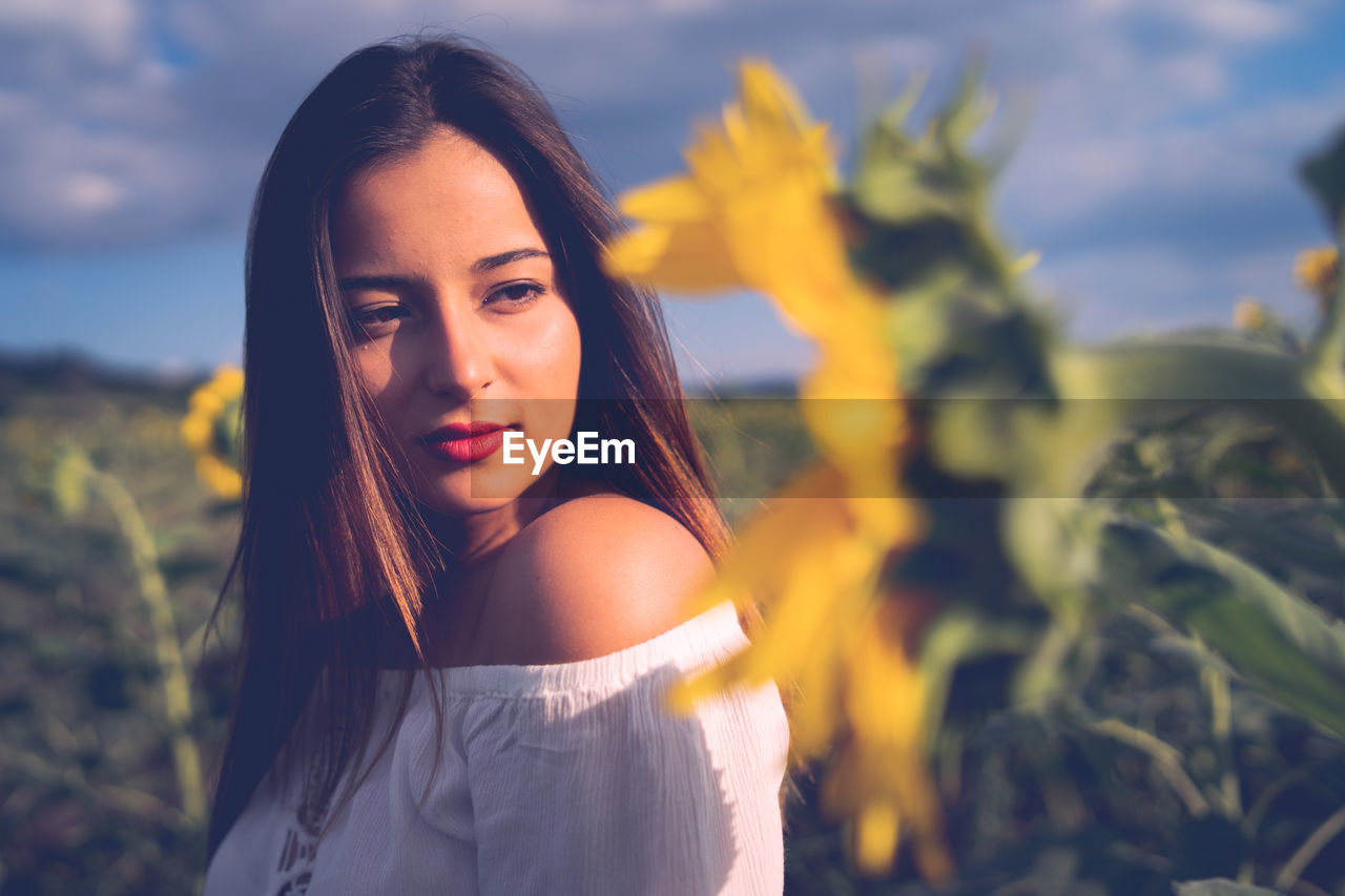 Teenage girl looking at sunflower