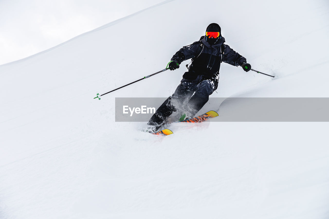 Male skier turns in loose snow, skier downhill downhill at ski resort