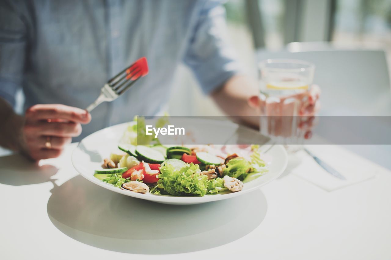 Midsection of man having food in plate