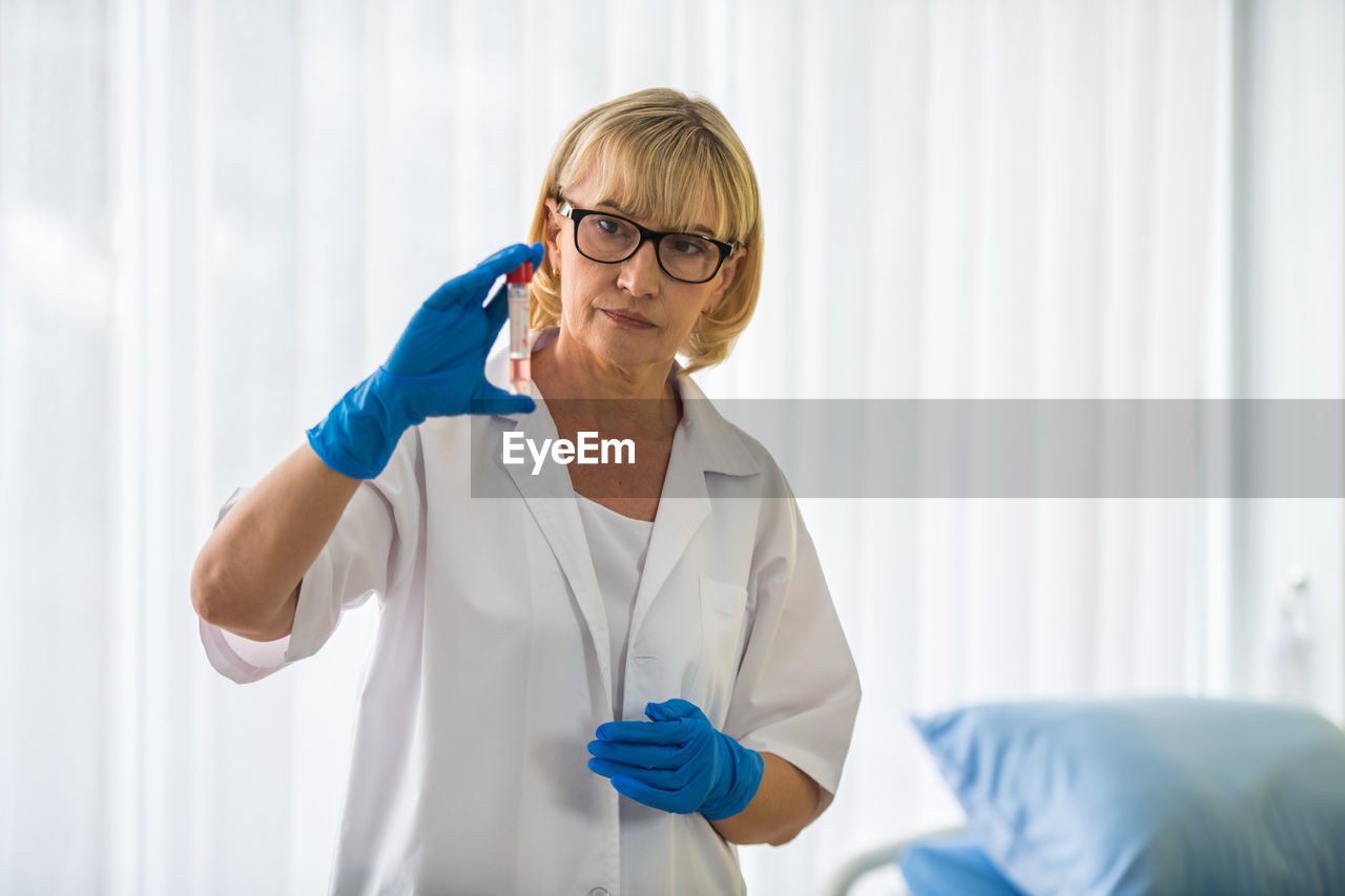 Female doctor examining test tube in hospital