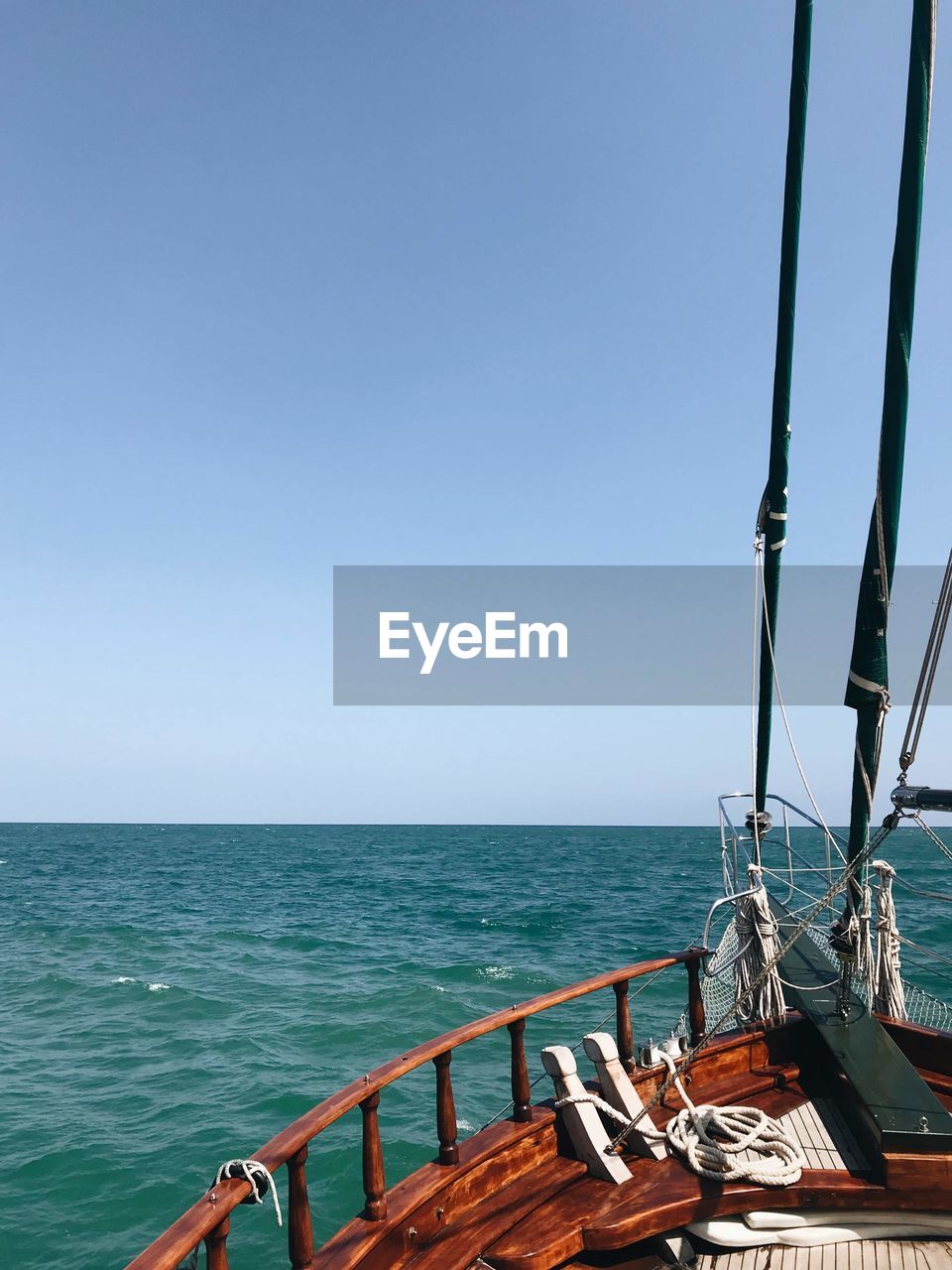 SAILBOAT BY SEA AGAINST CLEAR SKY