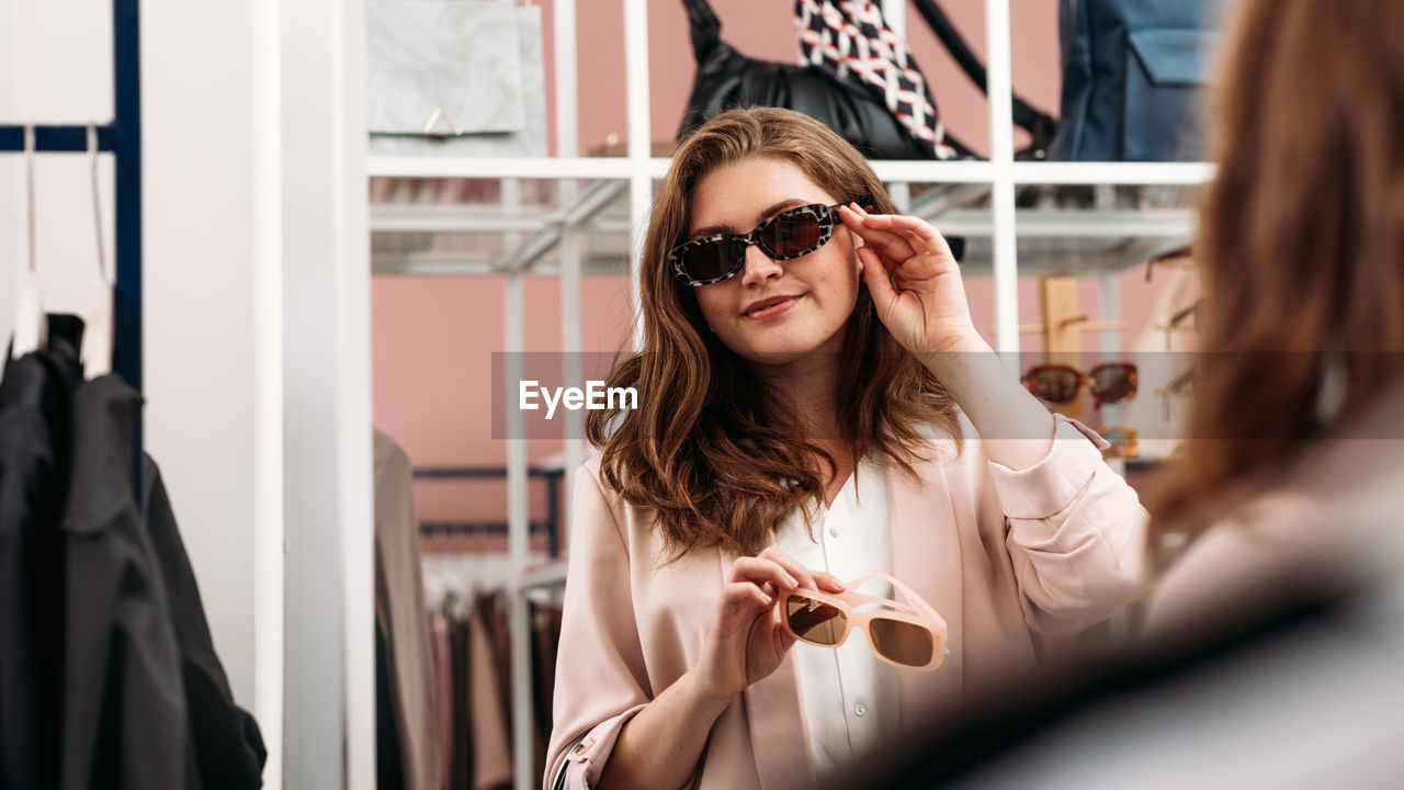 Young woman wearing sunglasses at store