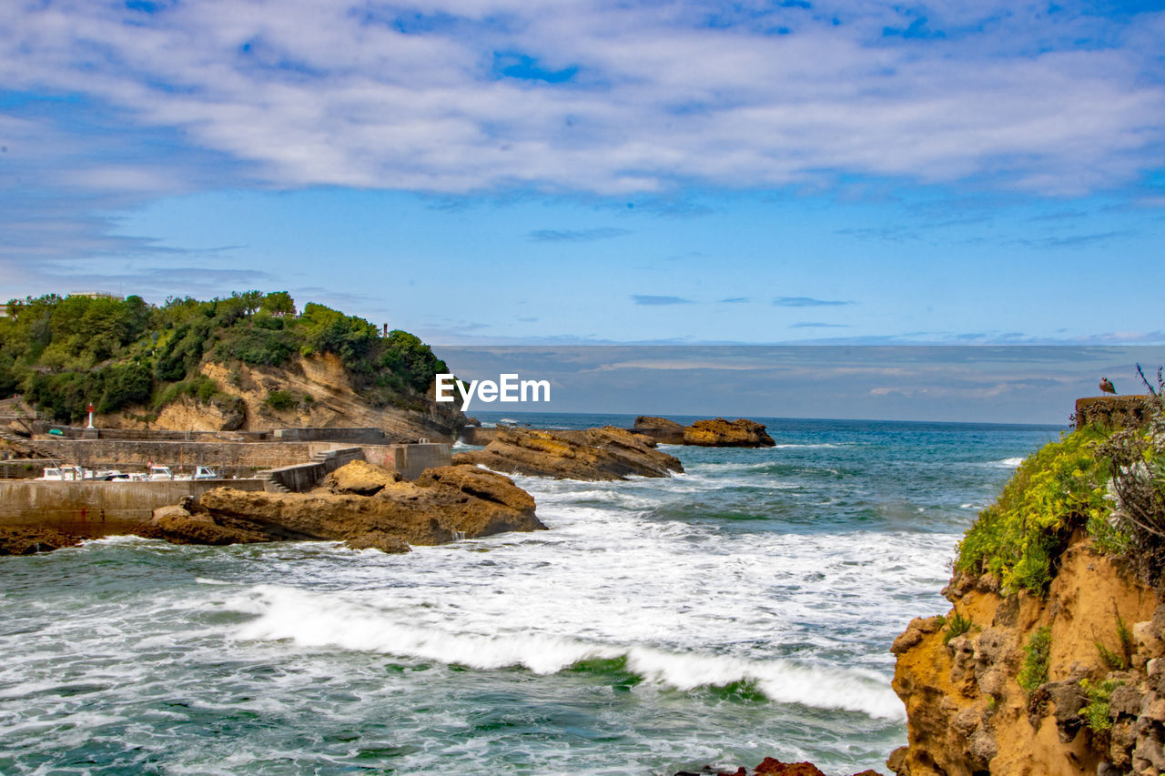 ROCKS ON SEA AGAINST SKY