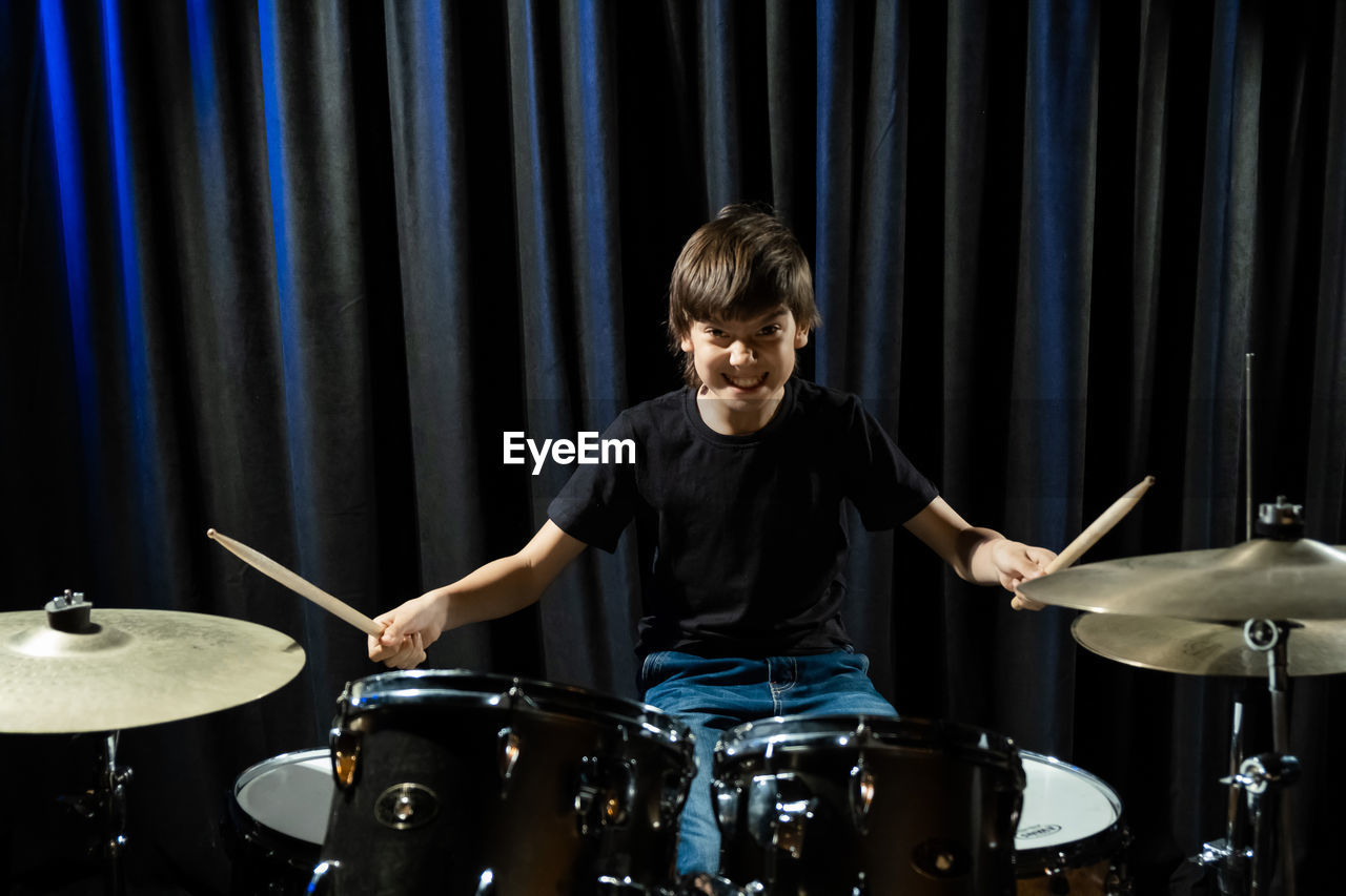 young man playing drum at night