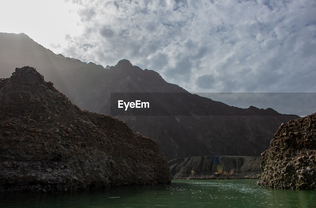 SCENIC VIEW OF ROCKS IN MOUNTAINS AGAINST SKY