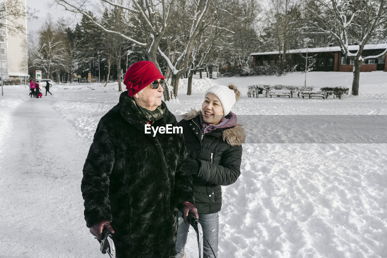 Senior woman with female home caregiver walking at winter