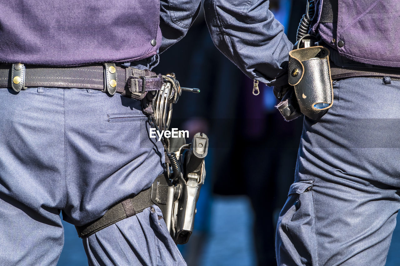 Rear view midsection of police with weapons