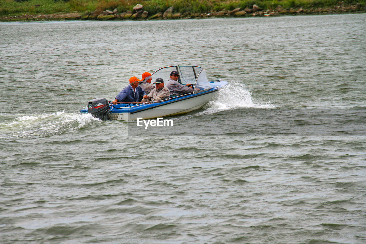 PEOPLE ON BOAT SAILING ON SEA