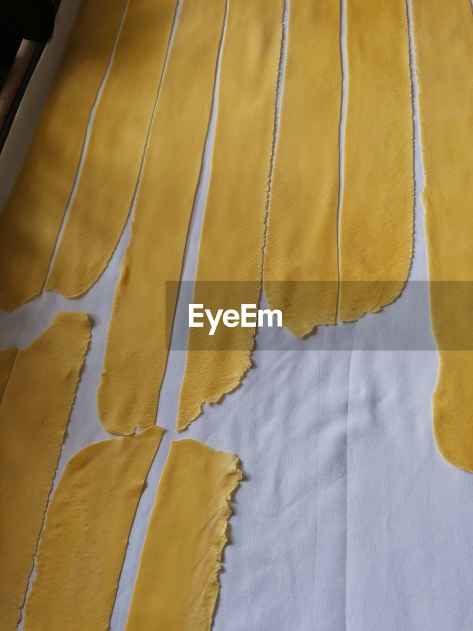 FULL FRAME SHOT OF YELLOW PAPER HANGING ON CLOTHESLINE
