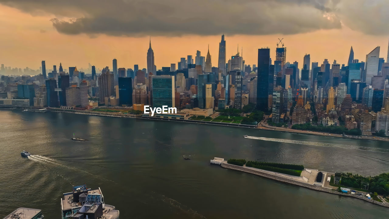 panoramic view of city by river against sky