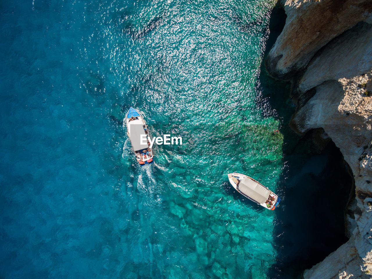 HIGH ANGLE VIEW OF PEOPLE SWIMMING ON ROCK