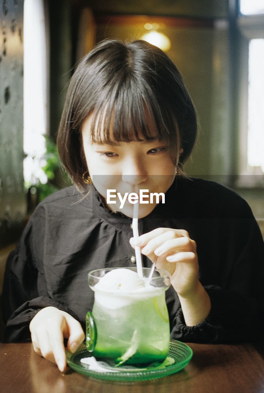 PORTRAIT OF A BOY DRINKING GLASS WITH DRINK