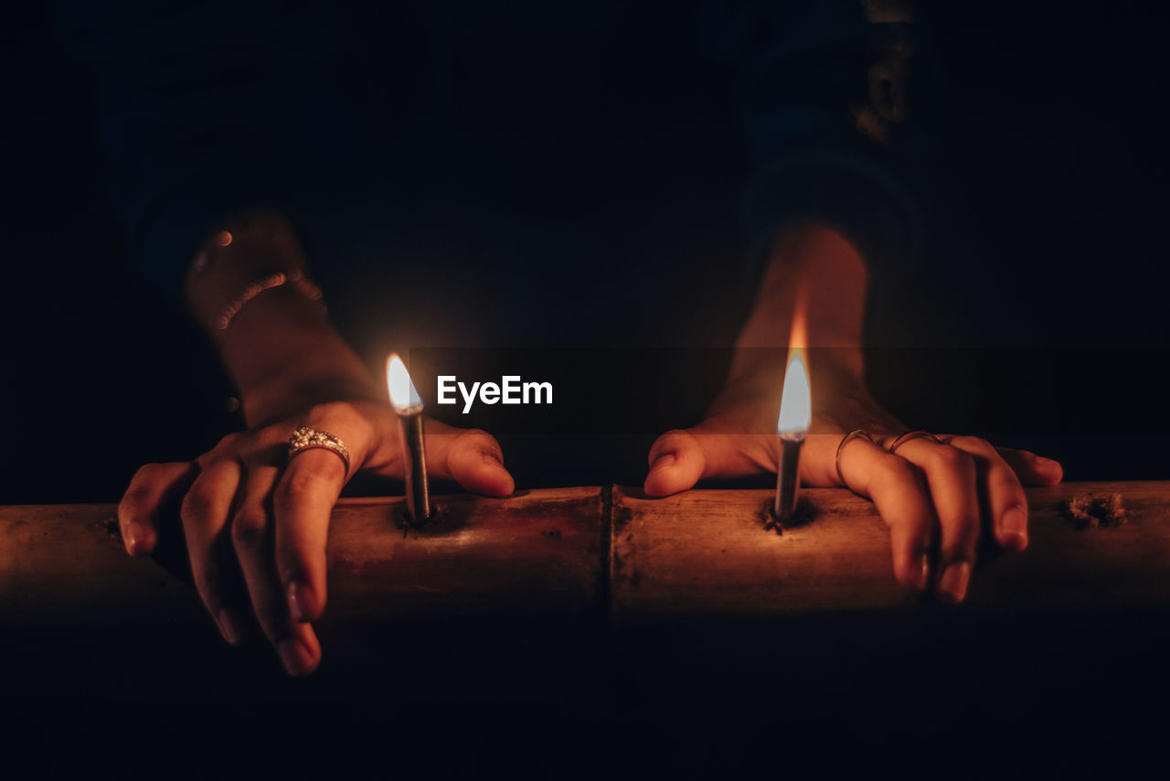 Close-up of hands burning candles
