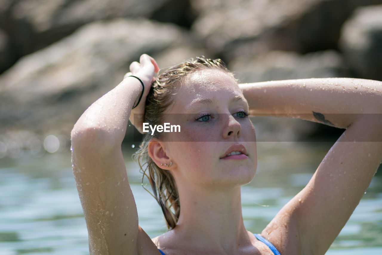 Close-up of woman with hand in wet hair