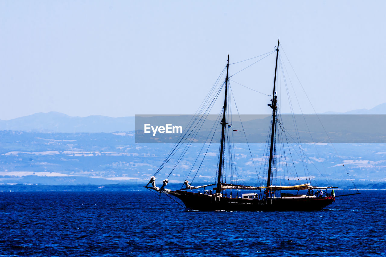 SAILBOAT SAILING IN SEA AGAINST CLEAR SKY