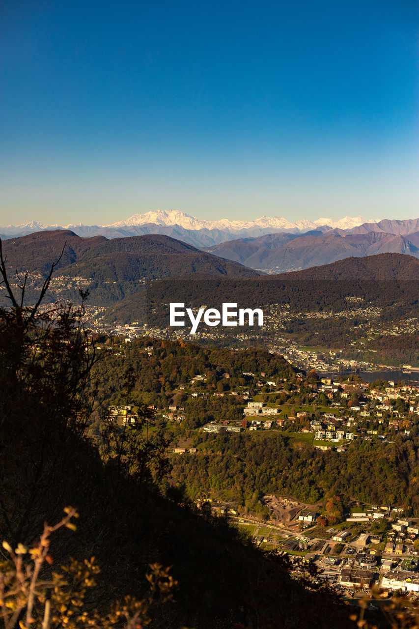 HIGH ANGLE VIEW OF TOWNSCAPE AGAINST MOUNTAIN RANGE