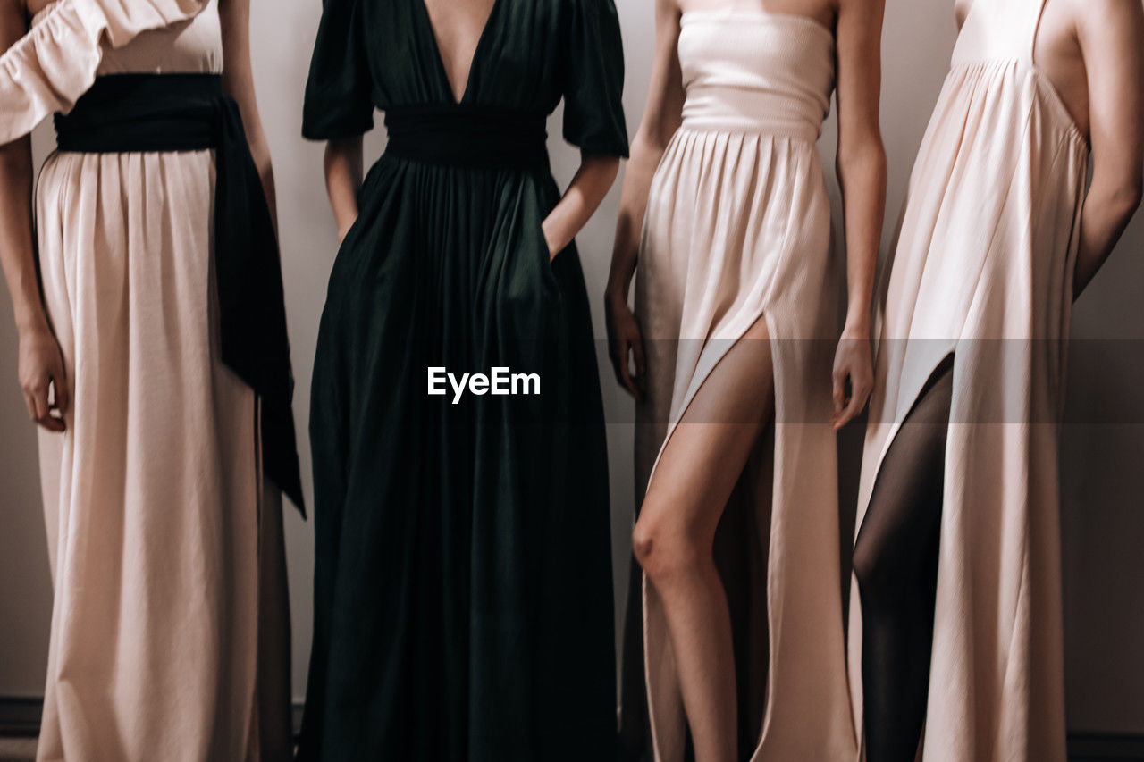 Elegant feminine fashion details of spring summer beige and green long dresses with slits