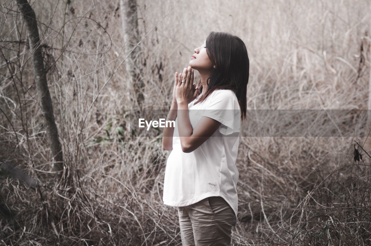 YOUNG WOMAN LOOKING AT FOREST