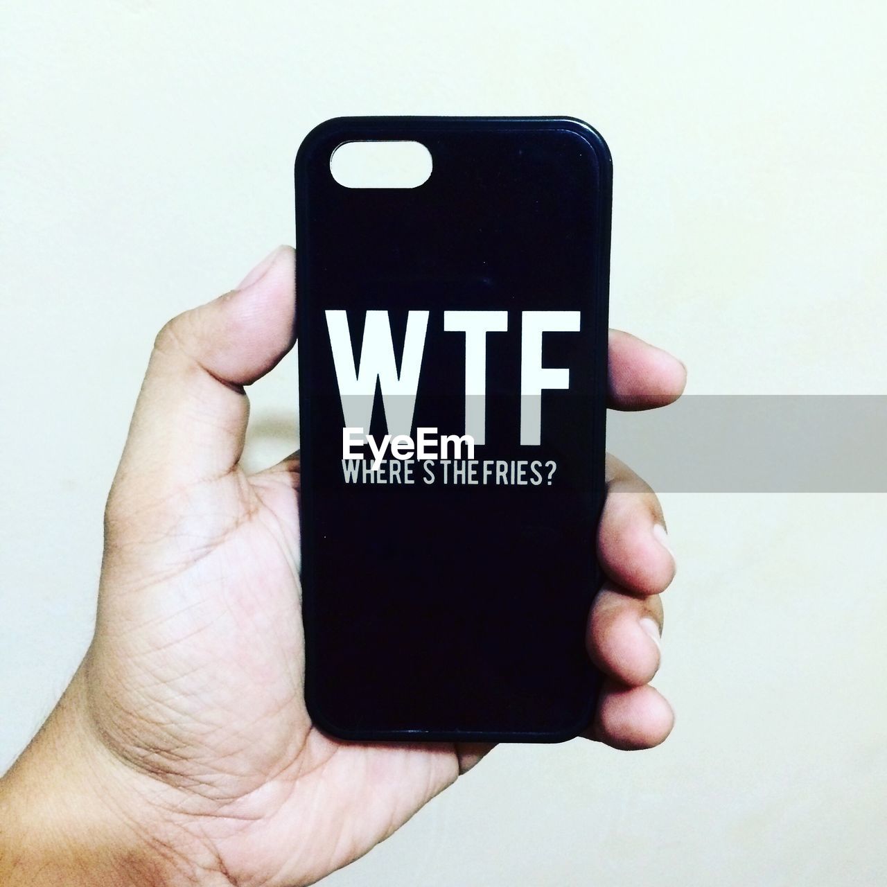 Cropped image of person holding phone cover with wtf text