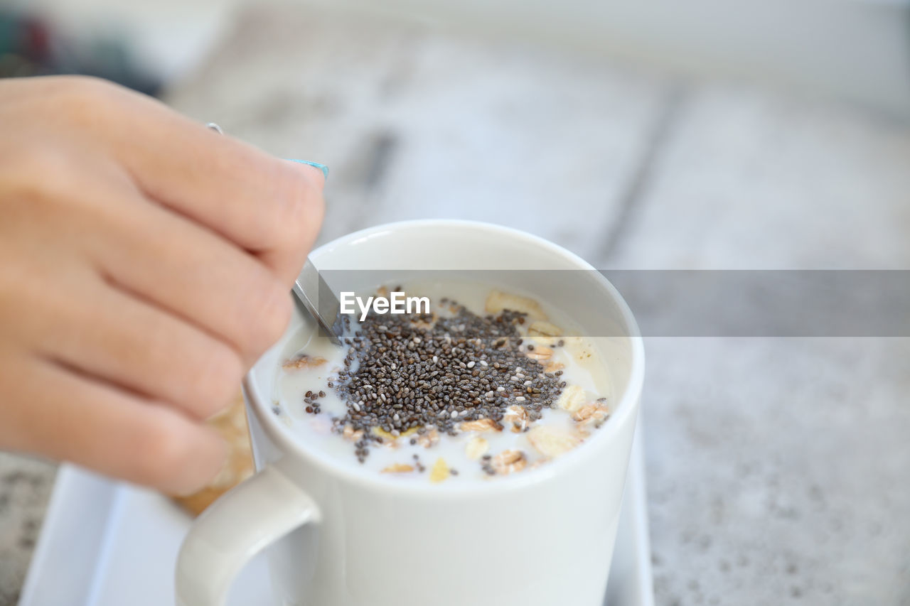 CROPPED IMAGE OF PERSON HOLDING COFFEE