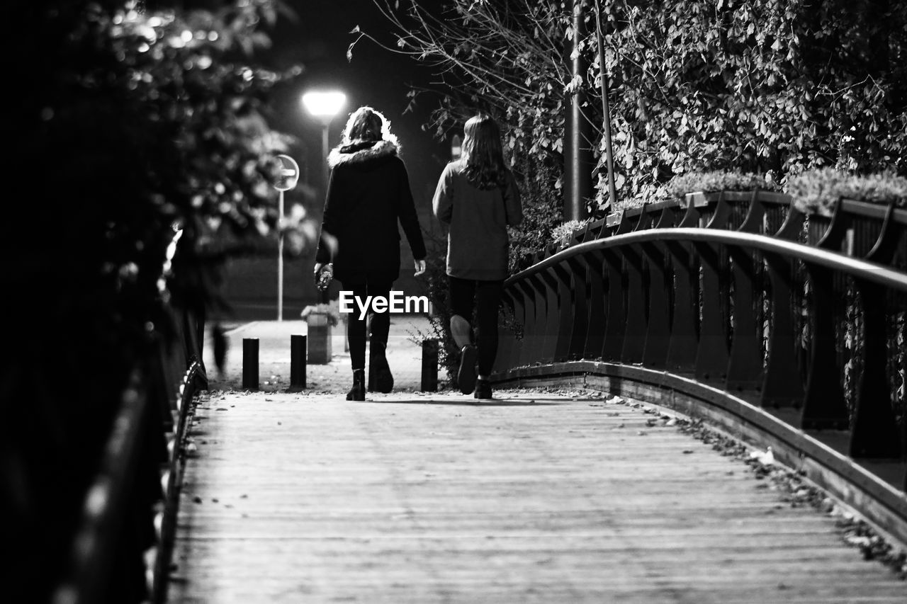 PEOPLE WALKING ON FOOTPATH AT NIGHT